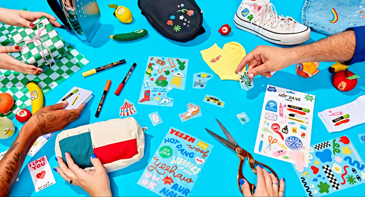 craft activity with iron on patches, markers, and scissors on a blue tablecloth. customizing bags, shoes, socks, and clothes.