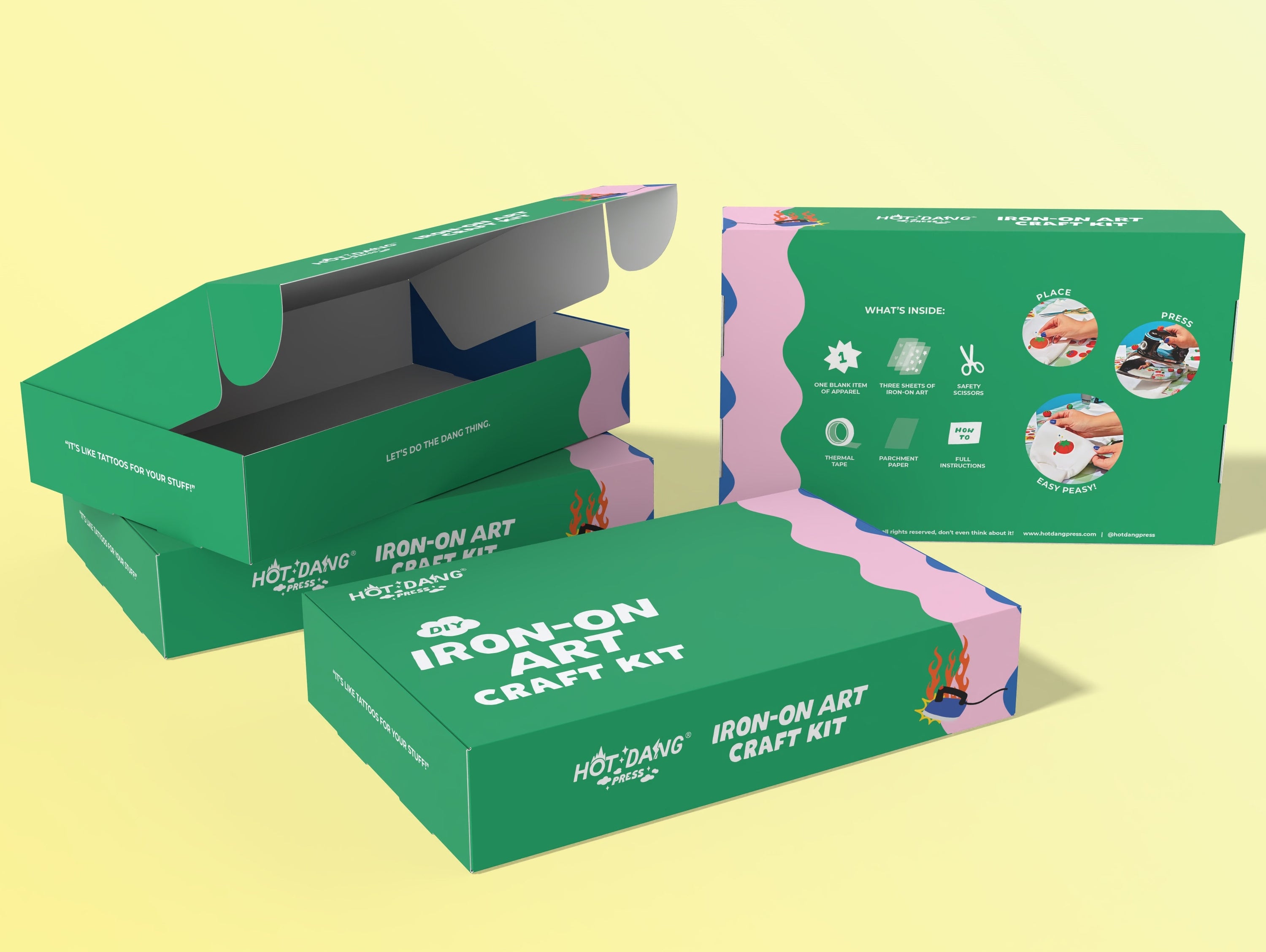  product boxes for an iron-on art craft kit arranged on a pale yellow background. The front box is closed with white text reading 'IRON-ON ART CRAFT KIT' and the Hot Dang Press logo. 